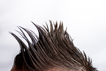 A man with a mohawk turned sideways on a white background