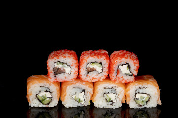 Philadelphia roll with salmon, cheese and cucumber on a black background with reflection. Sushi Philadelphia