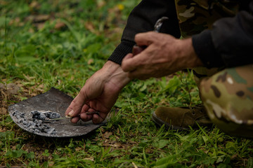 The man tries to burn the pipe with charcoal