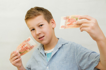 a schoolboy a boy of 10 years of Asian appearance holding in his hands banknotes of 5 thousand...