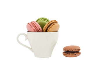 Macaroons in a cup and a dark brown macaroon
