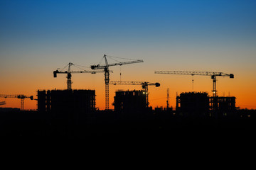 Construction crane and building construction site at sunset