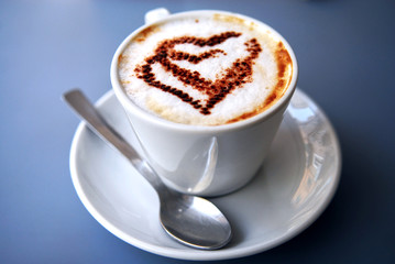 Nice closeup cup of coffee with hearts on coffee foam.  Coffee break in syle. Luxury relaxing lifestyle.