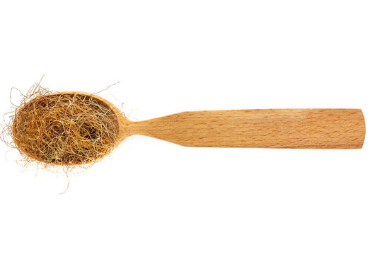 Dried corn stigmas in a wooden spoon on a white background. Phytotherapy and disease prevention. Herbal collection for medicinal tinctures. Herbal tea in folk medicine. The view from the top