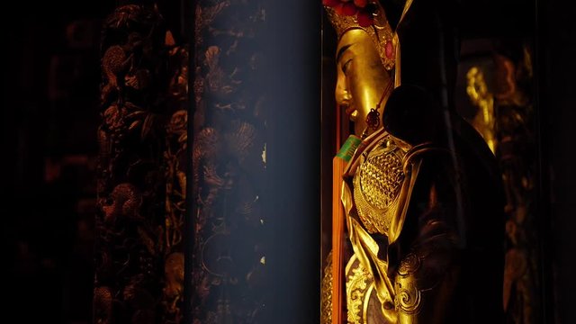 Golden Buddha statue through bars in Longshan Temple, Taipei, Taiwan.
High angle, parallax movement, slow motion, HD.