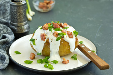 Stuffed baked potatoes with cheese and bacon with sour cream.