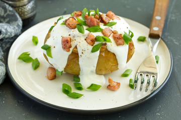 Stuffed baked potatoes with cheese and bacon with sour cream.