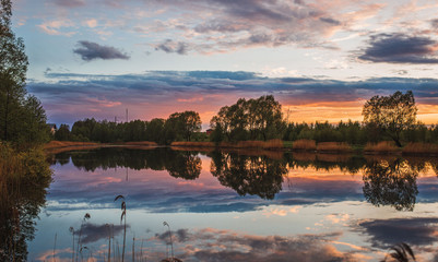 A perfect reflection of the sky in a city pond at sunset. High quality photography. Beautiful nature.