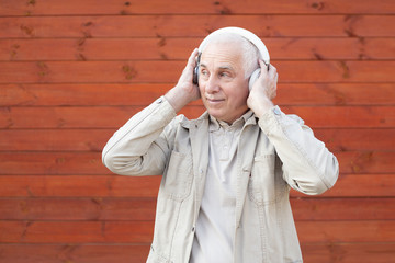 technology, people and lifestyle concept - happy senior man in headphones listening to music, successful senior businessman.