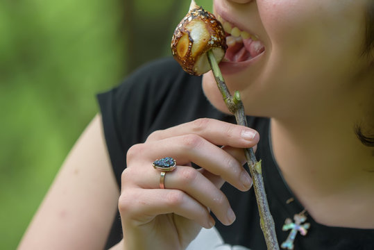 The girl eats, grilled on the fire masmelo