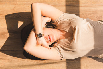 woman laying on floor. harsh sunlight