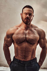 Fototapeta premium Athletic male model posing in sunlight, looking strong and serious