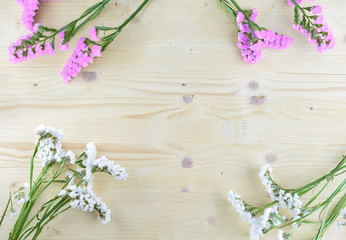 white and purple flowers on wooden background in aerial shot with copyspace