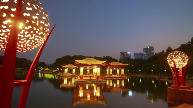 sunset time illumination foshan city famous lakeside park square pagoda reflection panoramic timelapse 4k china