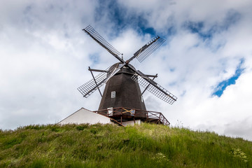 Fototapeta premium The historic Baunhoj Mill in Grenaa, Denmark. Old mill in black and white colors. mill for grinding grain for flour. cloudy sky in the background