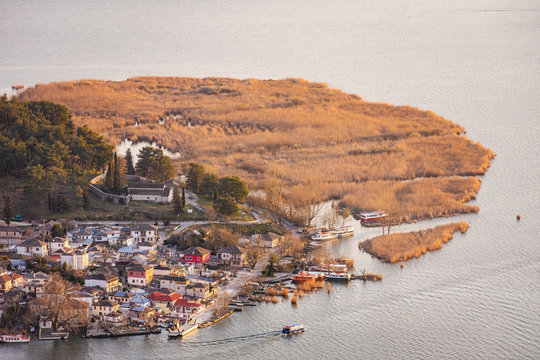 View of the small island of Kyra Frosini in lake Pamvotida with the ferry transporting tourists from Ioannina during sunset