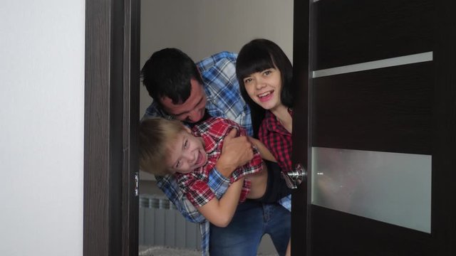 Happy Family Opens The Cheerful Door. Mom Dad And Son In A New Apartment Lifestyle . Man And Family Open Their House Smiling Joy