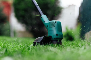 Mowing grass with electric trimmer