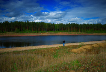 Fototapeta na wymiar Man standing on summer river bank background