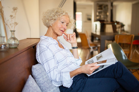 woman sitting at home reading magazine