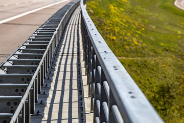 Fototapeta na wymiar Perspective view of motorway bridge metal railings with depth of field. 