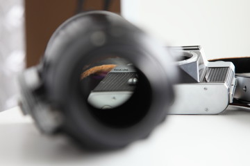 Lens adjustment, sharp writing in focus through a blurred aperture, vintage photographic equipment...