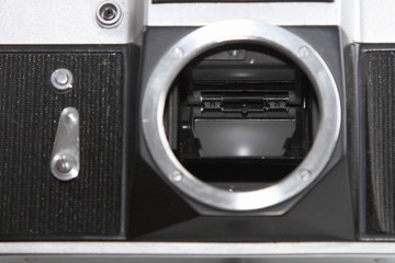 Close up vintage SLR camera front panel with mechanical timer, and lens mount with shutter mirror inside