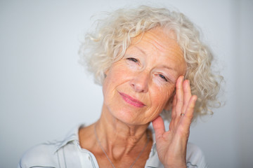 Close up elderly woman with headache and hand to head