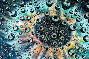 human eye close-up through drops of water on glass