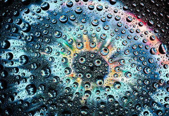 human eye close-up through drops of water on glass