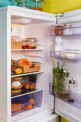 Opened fridge from the inside full of vegetables, fruits and other groceries beautiful order