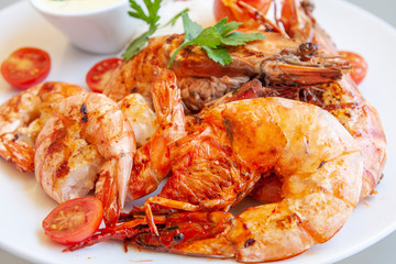 Several grilled tiger prawns on a white plate