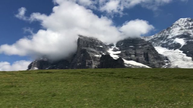 Mountain landscape with clouds.  View to Kleine Scheidegg from Mannlichen with Eiger, Monch and Jungfrau mountain (Swiss Alps) in the background, Berner Oberland, Grindelwald, Switzerland.