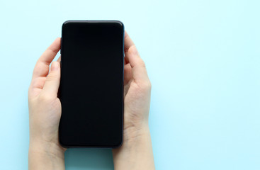 A black mobile phone with a dark empty touch screen smartphone in the hands of a Caucasian person.Selective focus. Space for text. Copy space. Work and communicate online. Product delivery order