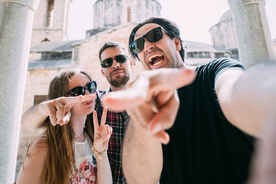 A Group Of Friends Takes A Selfie Against The Backdrop Of An Ancient Temple