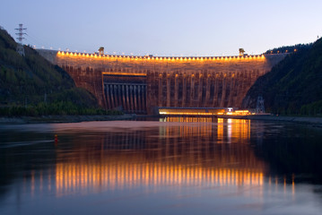 Hydroelectric power station at sunset with illumination of the upper upstream side