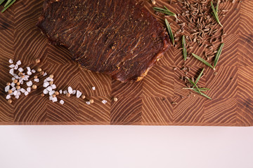 Close-up of a piece of meat on a wooden Board with spices. Restaurant menu, a series of photos of different dishes