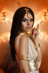 woman queen Cleopatra art photo. Creative golden makeup Black hair braids. Carnival ethnic egypt...