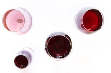 Four glasses of wine: red and pink on white background with sparkling shadows. Top view. Free copy space.  Concept of organic drinks. Banner