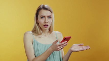 Unhappy young blonde woman reading negative message on smartphone worrying thinking expressing sadness posing on background. Bad news. Expressions.