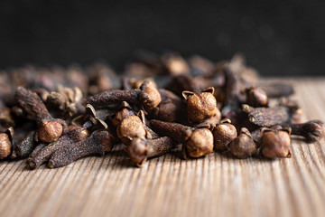 Dried clove spices on a wooden board.