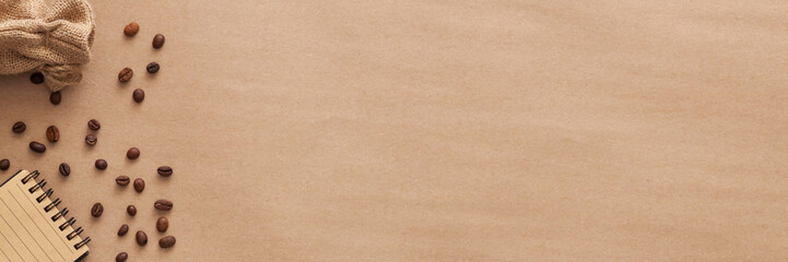 Spilled coffee beans on a brown background. Copy space. Panorama