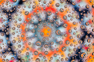 multi-colored mandala through drops of water on glass