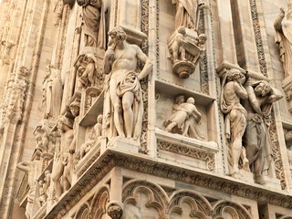 Bas reliefs and sculptures on the walls of the famous Milan Cathedral in Italy. December 2017