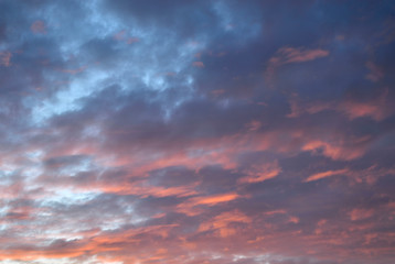 Blue red sunset sky with illuminated clouds