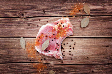 Steak meat with seasonings on a wooden background