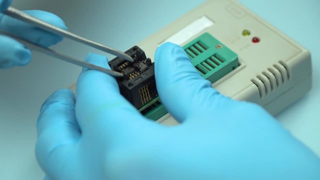The wizard inserts a chip into the programmer through an adapter, soic8, to program the chip. Technology.