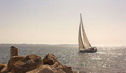 Sailing at Sunset off a Rocky Coast