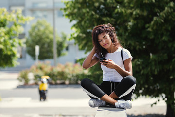 Fototapeta na wymiar beautiful young woman using her smartphone in the street