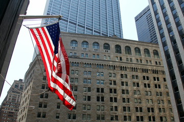 US Flag flying on the background of the facade of the Federal Reserve building in New York - July...